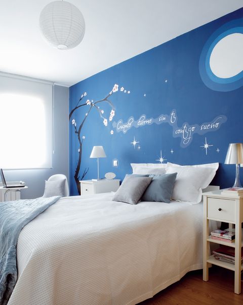 dormitorio con pared de cabecero azul